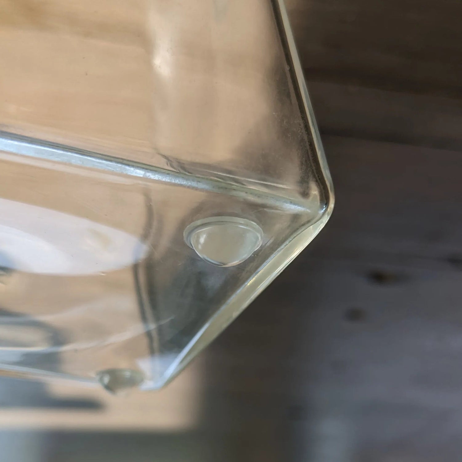 Clear domed self-adhesive bumper affixed to a glass vase base.