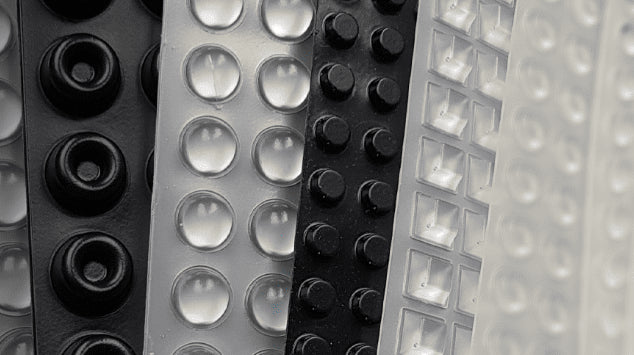 Close-up of black and clear sheets of bumper feet of different shapes and sizes